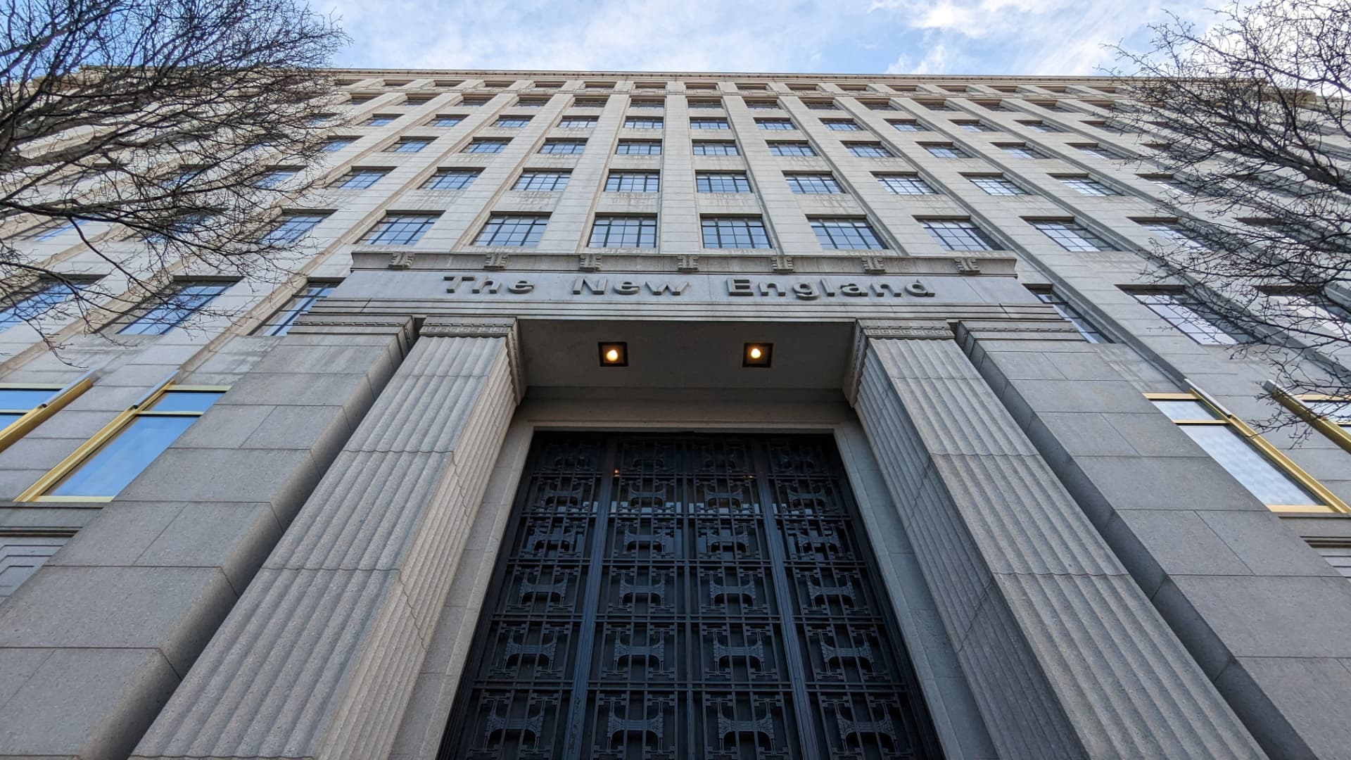 Upward view of 501 Boylston Street in Boston, the limestone New England building entrance with fluted columns